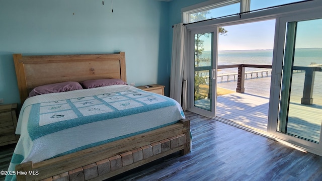 bedroom featuring a water view, dark hardwood / wood-style floors, and access to exterior