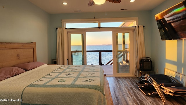 bedroom featuring hardwood / wood-style flooring, access to exterior, and multiple windows