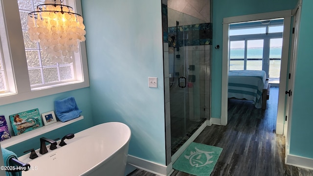 bathroom with french doors, wood-type flooring, plus walk in shower, and a water view