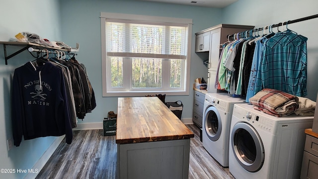 washroom featuring cabinets, wood-type flooring, and washer and dryer