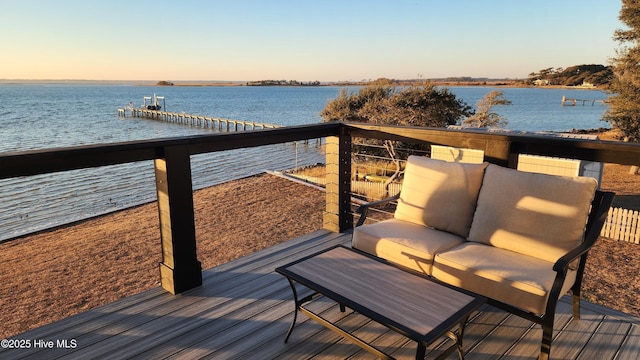 deck at dusk featuring a water view