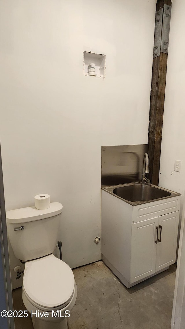 bathroom featuring vanity, toilet, and concrete floors