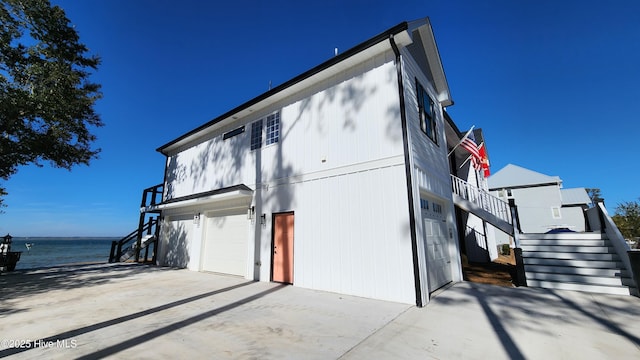 view of property exterior featuring a garage and a water view