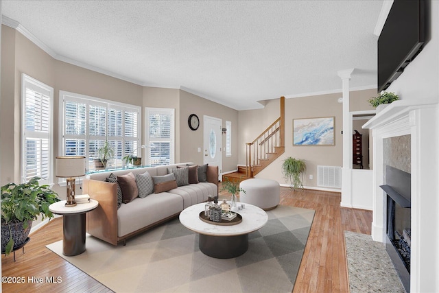 living room featuring crown molding, hardwood / wood-style floors, and a textured ceiling