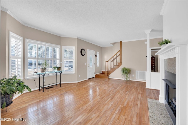 foyer with hardwood / wood-style flooring, crown molding, and a textured ceiling