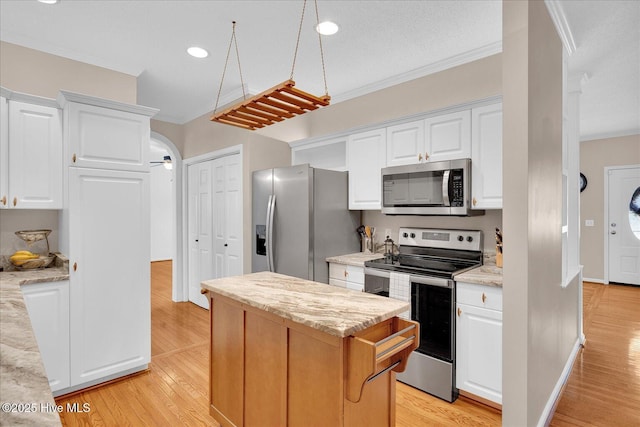 kitchen featuring stainless steel appliances, ornamental molding, light stone countertops, and white cabinets