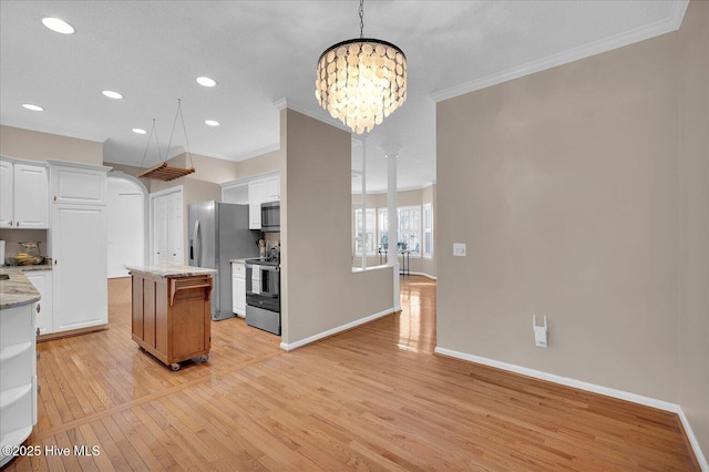 kitchen featuring light stone countertops, white cabinetry, appliances with stainless steel finishes, and a center island