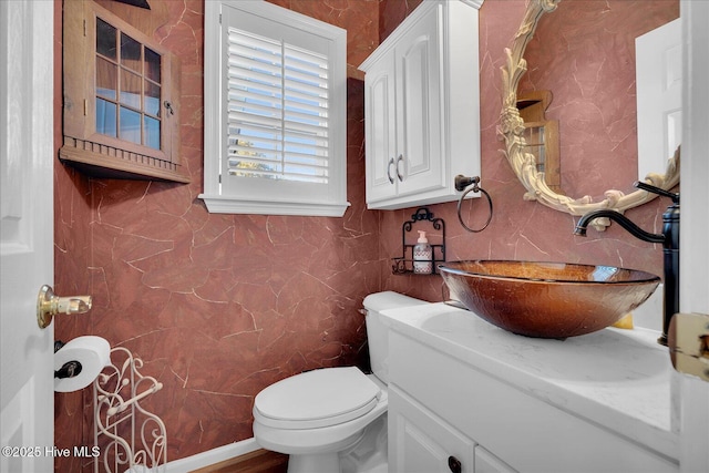 bathroom featuring vanity, toilet, and tile walls