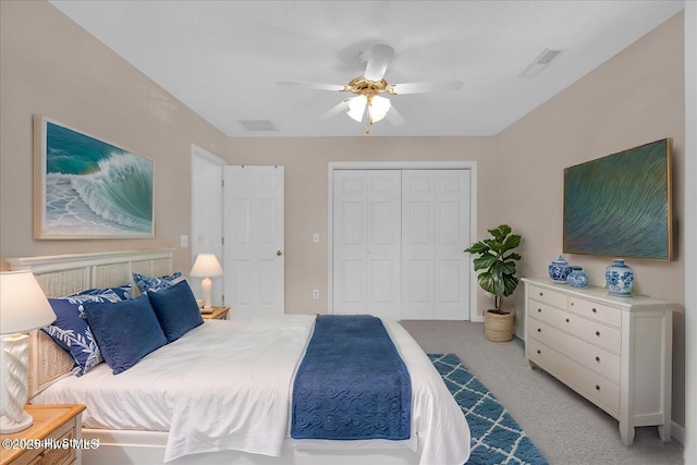 carpeted bedroom with ceiling fan and a closet