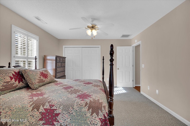 bedroom featuring ceiling fan, a closet, a textured ceiling, and carpet