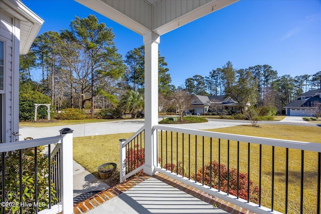 wooden deck featuring a porch and a yard