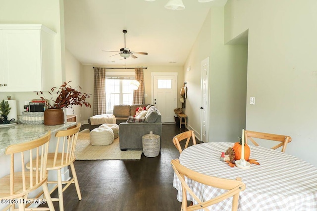 dining area featuring ceiling fan, dark hardwood / wood-style flooring, and vaulted ceiling