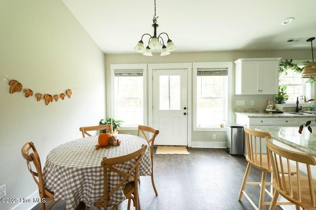 dining area featuring an inviting chandelier, dark hardwood / wood-style flooring, and sink