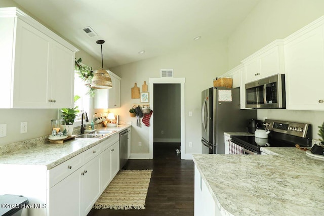 kitchen with stainless steel appliances, sink, white cabinets, and decorative light fixtures