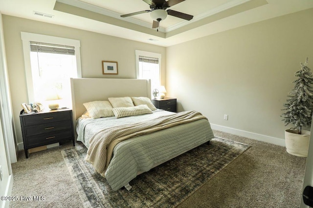 bedroom with crown molding, ceiling fan, a raised ceiling, and dark carpet