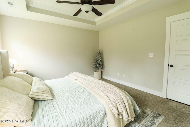 carpeted bedroom with a raised ceiling, crown molding, and ceiling fan