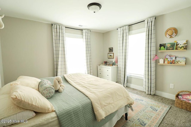 carpeted bedroom featuring multiple windows