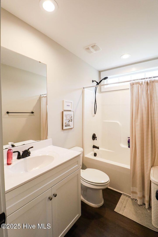 full bathroom featuring vanity, hardwood / wood-style flooring, toilet, and shower / bath combo with shower curtain