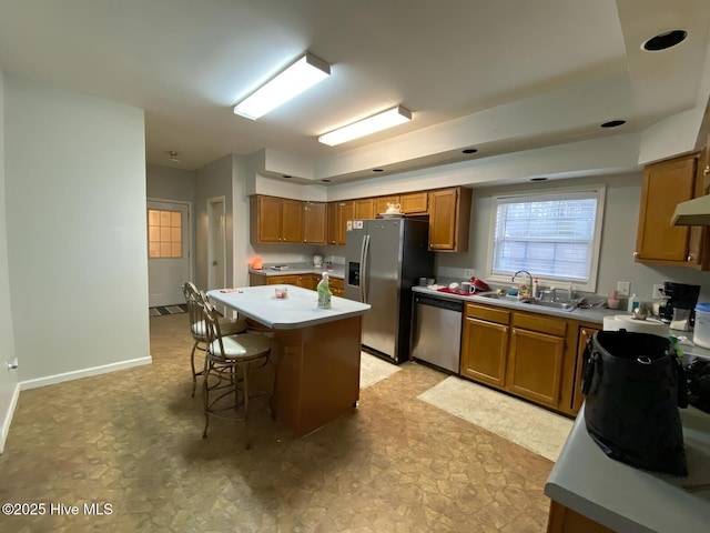 kitchen featuring appliances with stainless steel finishes, a kitchen breakfast bar, sink, and a kitchen island