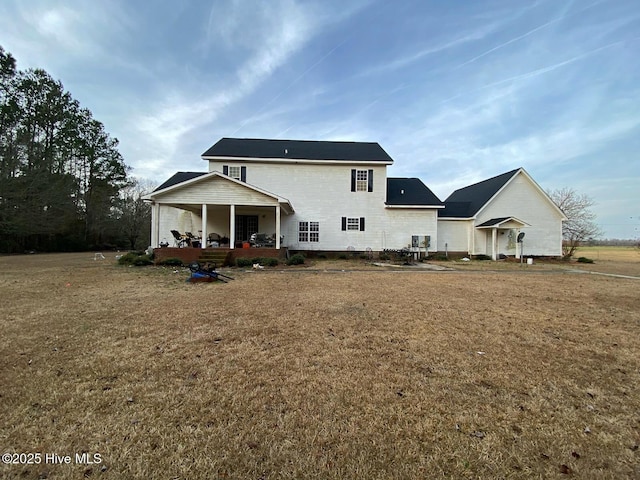 back of house with a yard, central AC unit, and covered porch