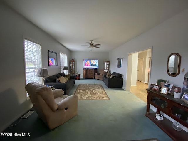 carpeted living room with ceiling fan