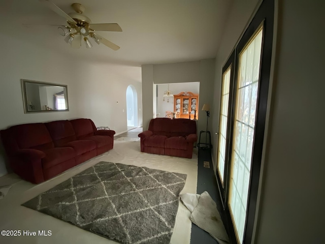 living room with plenty of natural light, ceiling fan, and carpet flooring