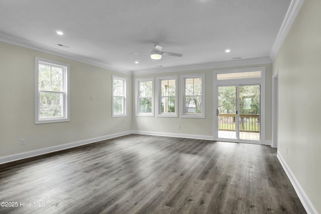 spare room with baseboards, a healthy amount of sunlight, ornamental molding, and dark wood finished floors