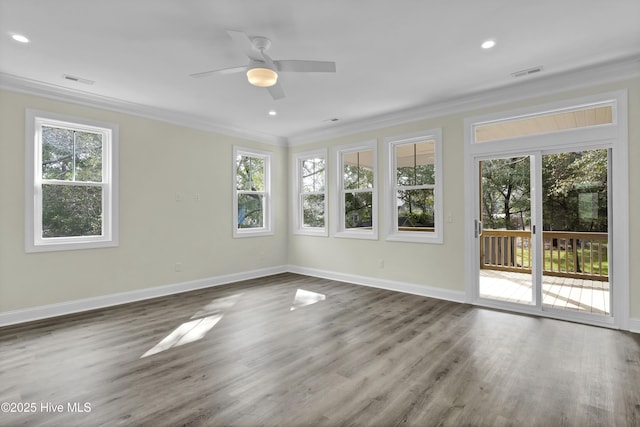 interior space featuring wood finished floors, baseboards, visible vents, and ornamental molding