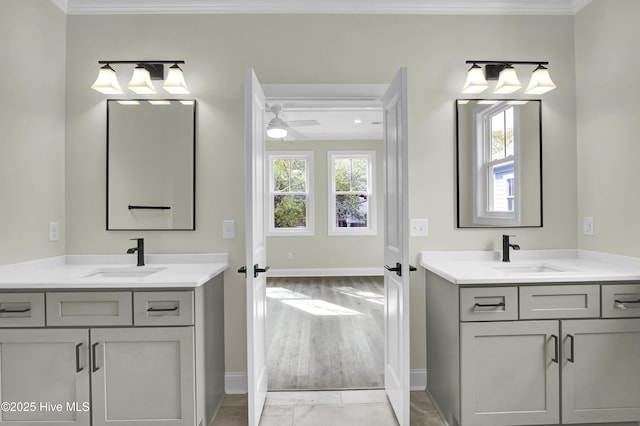 bathroom with two vanities, crown molding, and a sink