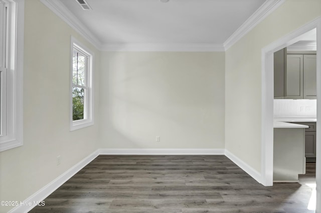 spare room with crown molding, dark wood-style floors, and visible vents