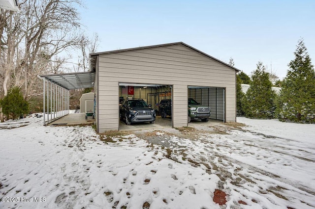 snow covered garage with a carport