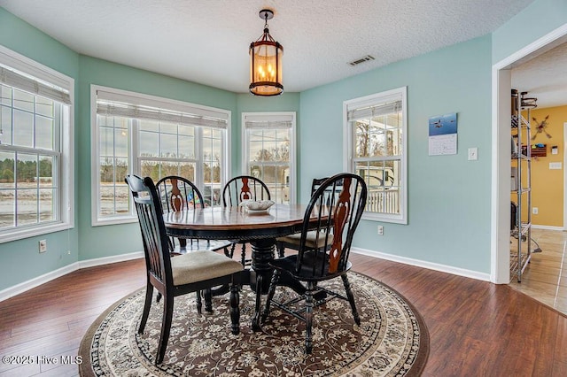 dining space featuring dark hardwood / wood-style floors and a textured ceiling