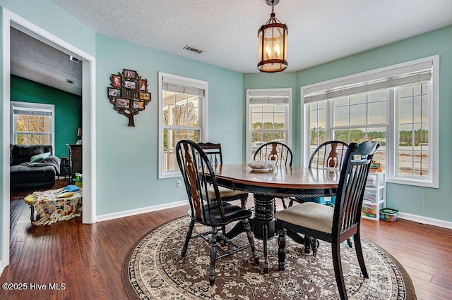 dining room featuring dark hardwood / wood-style flooring and a textured ceiling