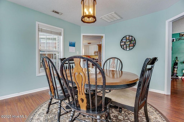 dining space with dark hardwood / wood-style flooring and a textured ceiling