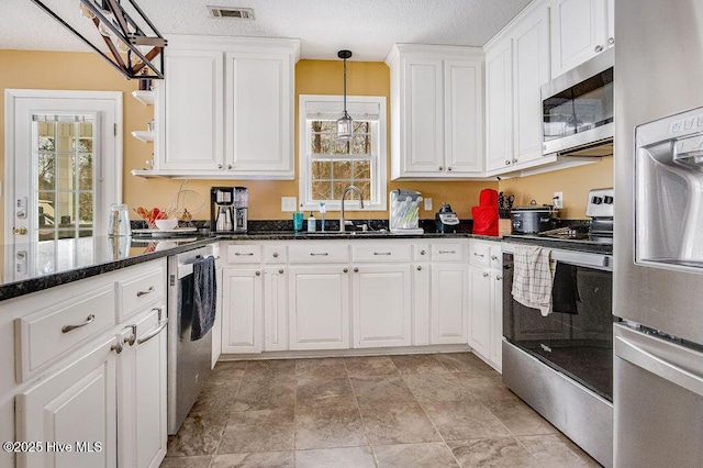 kitchen with white cabinetry, sink, pendant lighting, and appliances with stainless steel finishes