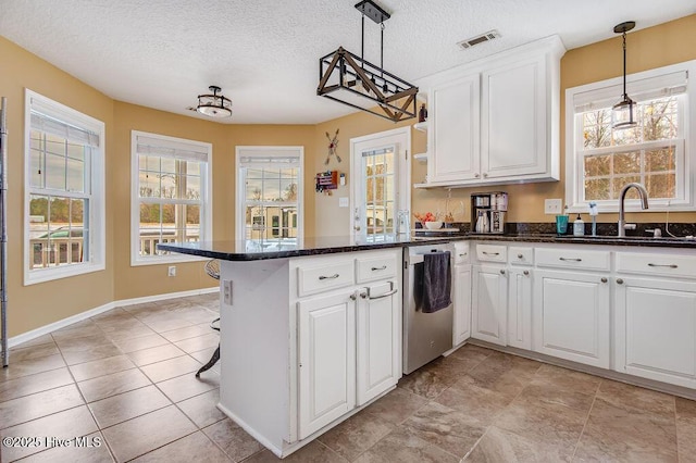 kitchen with white cabinetry, kitchen peninsula, sink, and hanging light fixtures