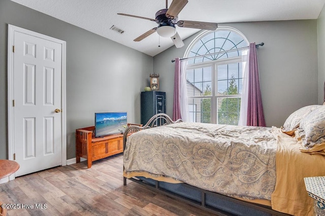 bedroom featuring ceiling fan, wood-type flooring, and vaulted ceiling