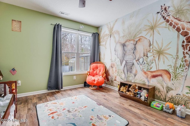 rec room featuring hardwood / wood-style floors and a textured ceiling