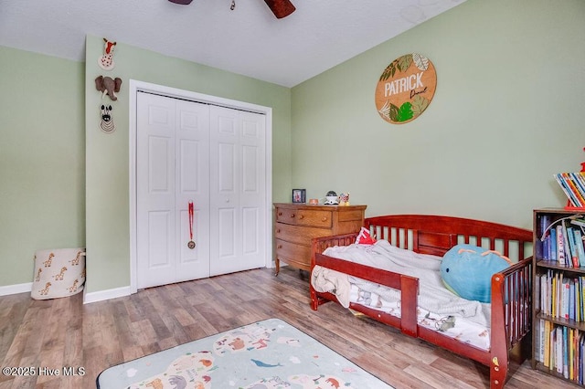 bedroom with wood-type flooring, a closet, and ceiling fan