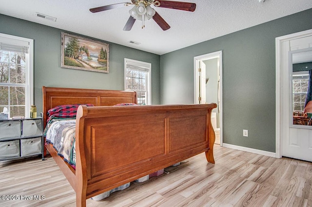 bedroom featuring ceiling fan, a textured ceiling, and light wood-type flooring