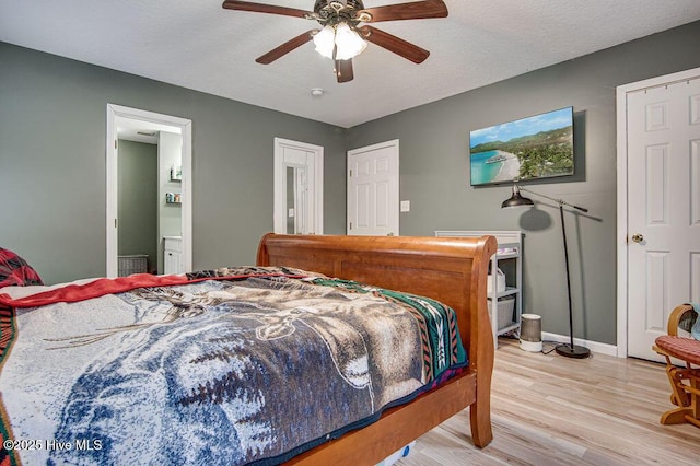 bedroom featuring ceiling fan, ensuite bathroom, and light hardwood / wood-style flooring