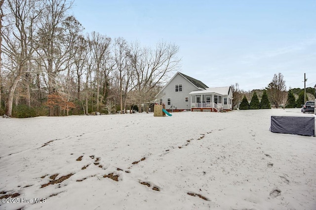 view of snow covered back of property