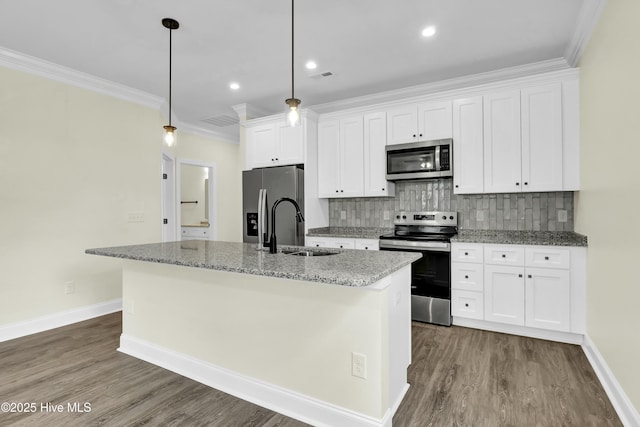 kitchen with sink, appliances with stainless steel finishes, a kitchen island with sink, white cabinets, and decorative light fixtures