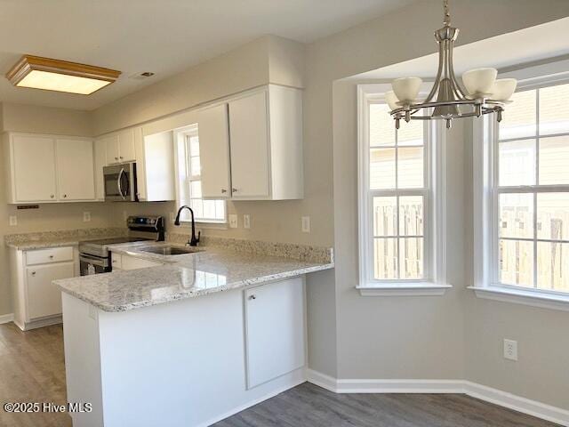 kitchen with white cabinetry, appliances with stainless steel finishes, kitchen peninsula, and sink