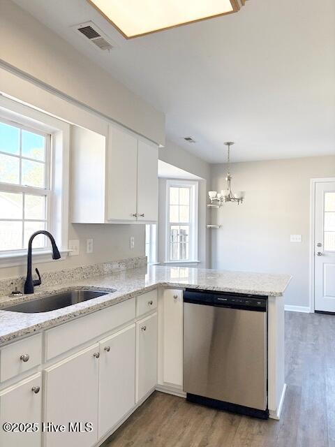 kitchen featuring sink, white cabinetry, stainless steel dishwasher, kitchen peninsula, and pendant lighting