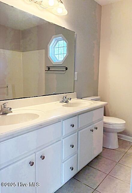 bathroom featuring vanity, tile patterned floors, and toilet