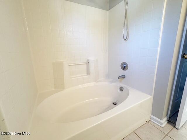 bathroom with tiled shower / bath and tile patterned floors