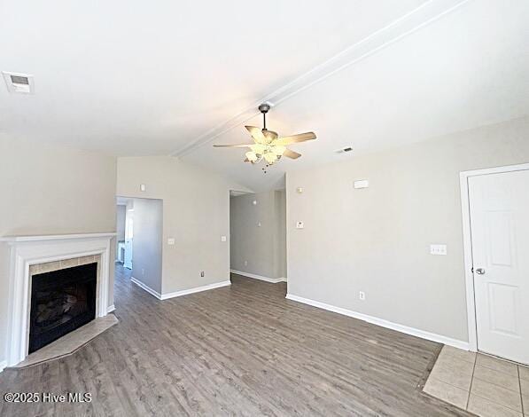 unfurnished living room featuring lofted ceiling with beams, wood-type flooring, ceiling fan, and a fireplace