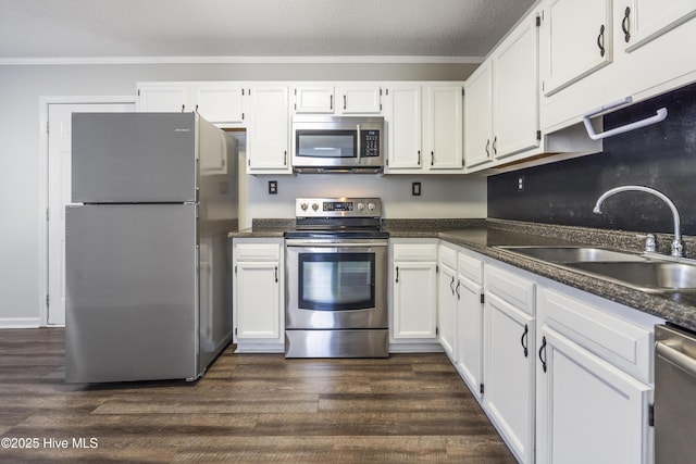 kitchen with stainless steel appliances, white cabinetry, and sink