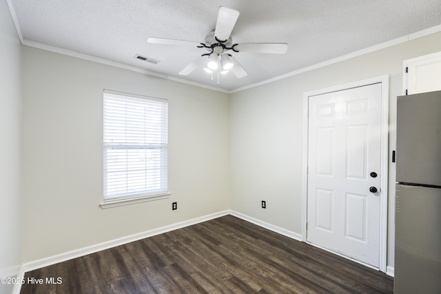 unfurnished bedroom with crown molding, dark wood-type flooring, stainless steel fridge, and a textured ceiling